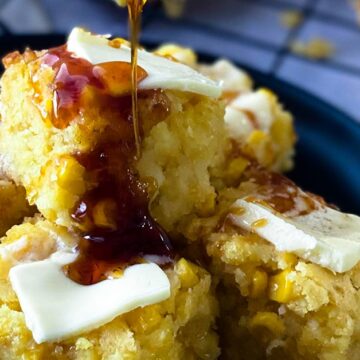 Drizzling honey onto slices of creamed corn casserole with pats of butter on top