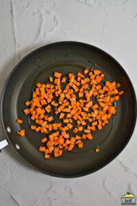 Frying diced carrots in a pan
