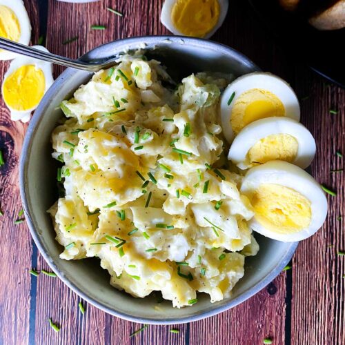 egg and potato salad in a bowl with a fork