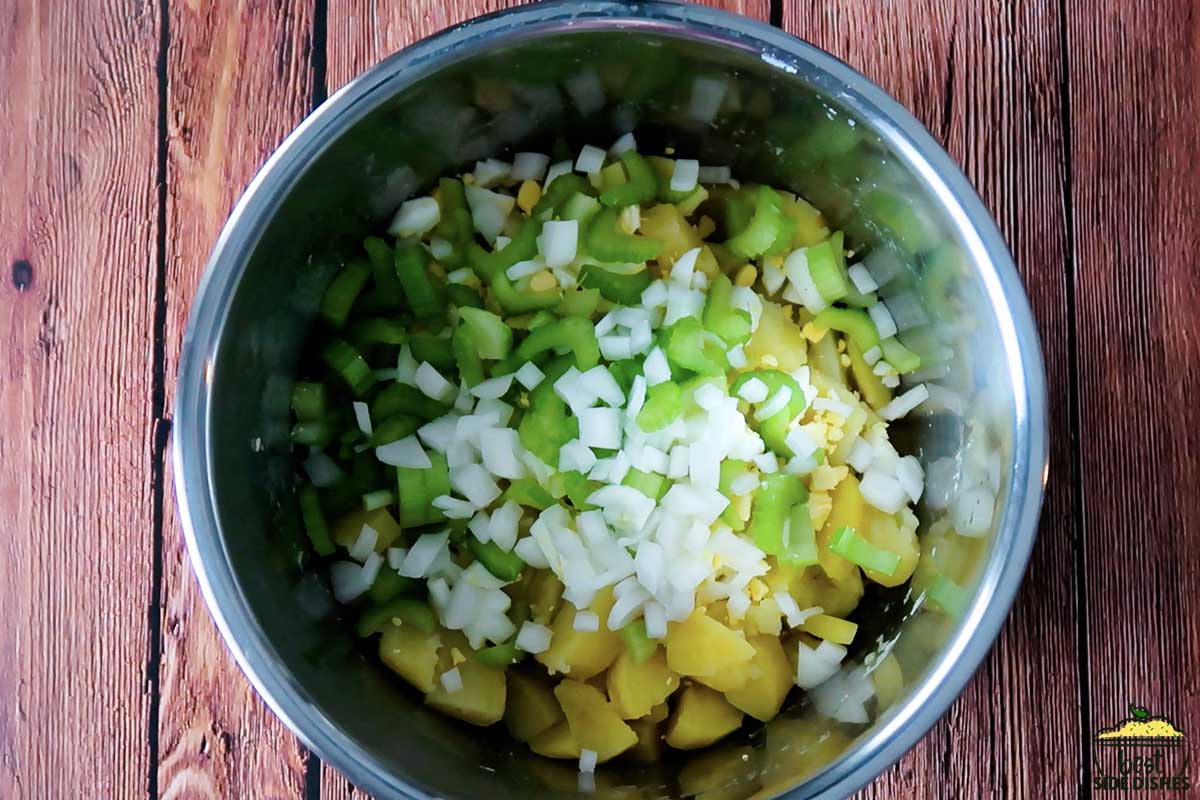 mixing celery and onions into potatoes