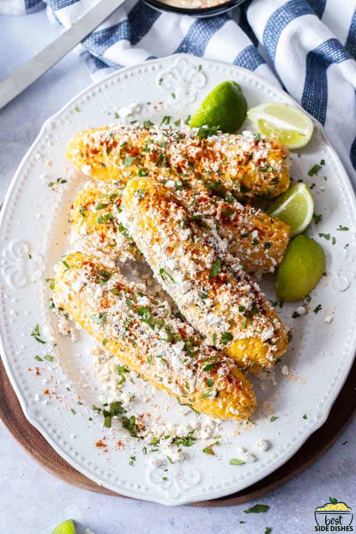 Mexican street corn on a white platter with lime wedges