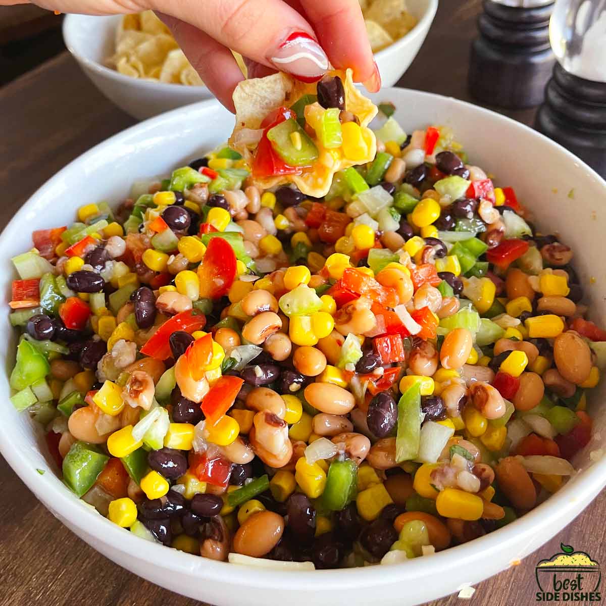 Dipping a chip in black eyed peas salad