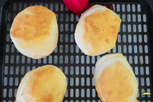 4 cooked biscuits on an air fryer tray