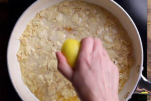squeezing lemon into sliced almonds in butter