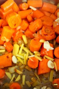 carrots, onions, garlic and ginger being sauteed in an instant pot