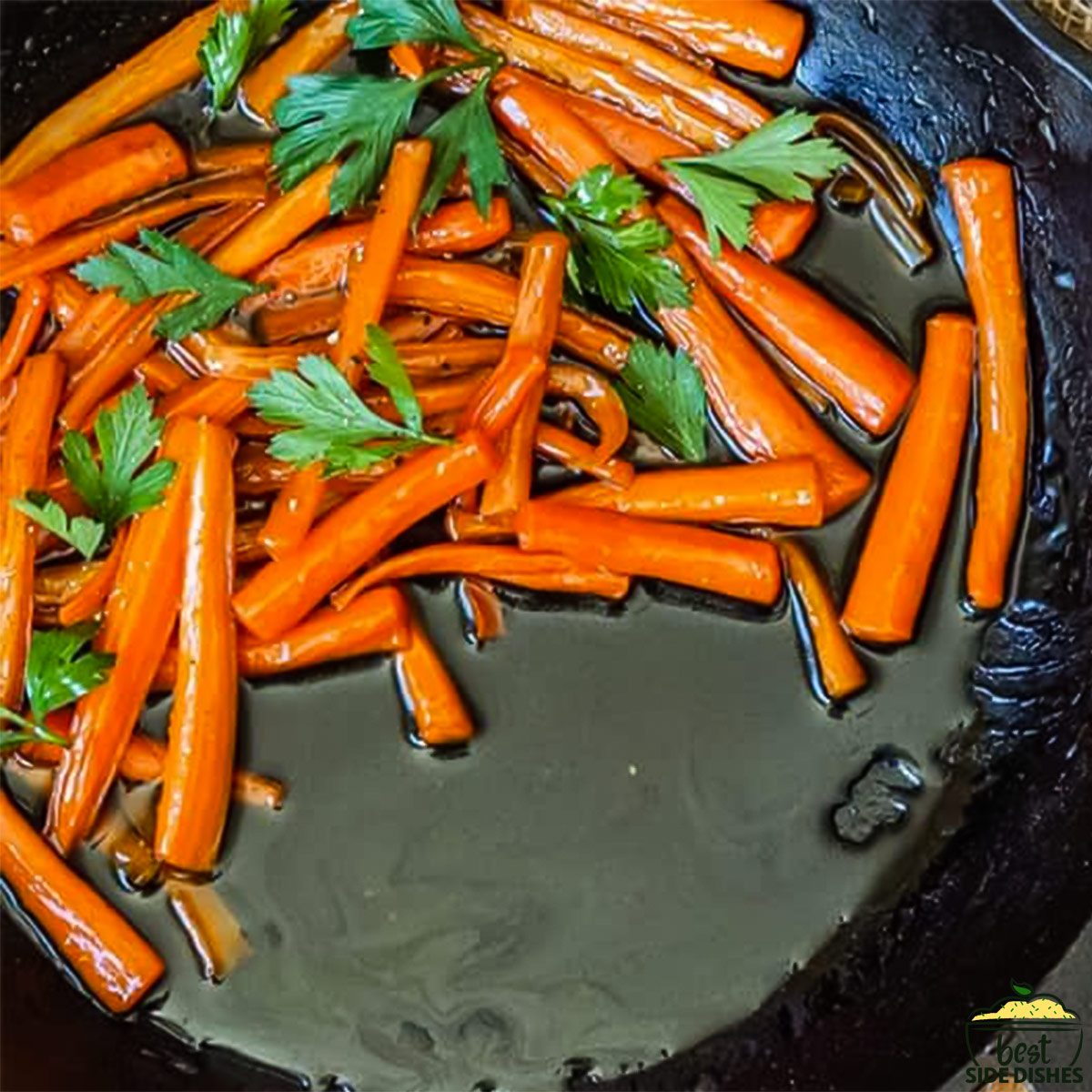 a closeup of a cast iron pan with maple glazed carrots in it