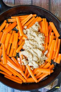 uncooked, sliced carrots, butter, brown sugar and maple syrup in a pan