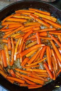 carrots in simmering maple glaze in a cast iron pan