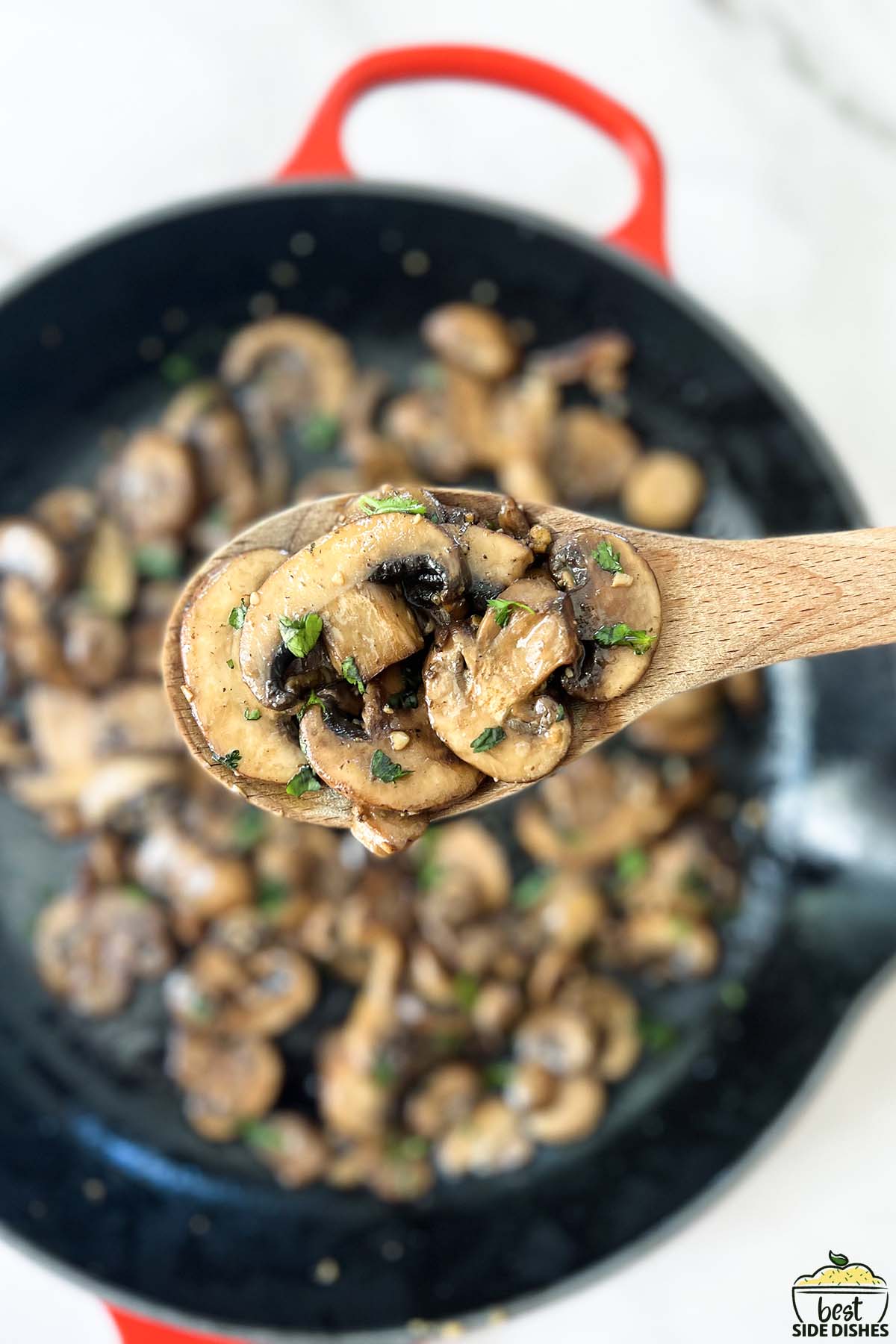 sauteed mushrooms up close on a wooden spoon