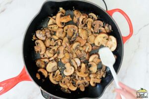 stirring mushrooms with garlic