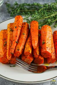 a plate of air fryer carrots with herbs and a fork