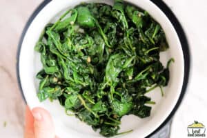 sautéed spinach in a white bowl ready to serve