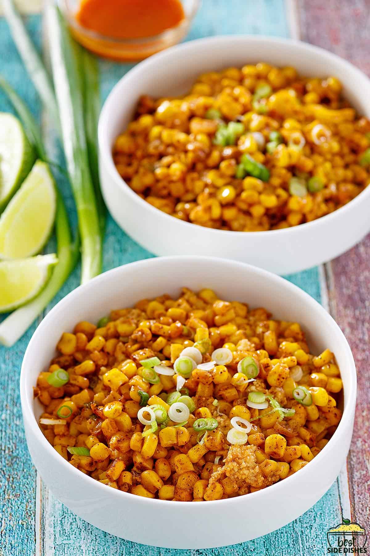 two bowls of Mexican corn casserole with green onions for garnish