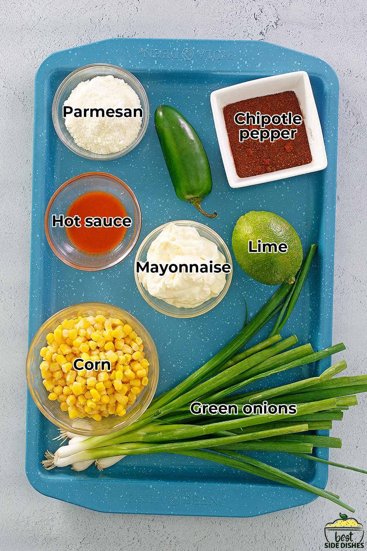 all the ingredients for Mexican corn casserole on a blue baking tray