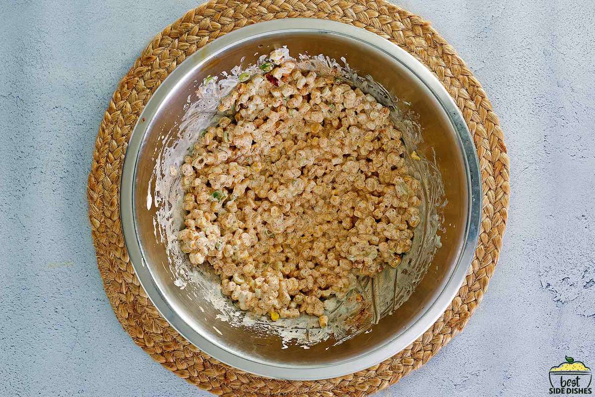 mixed together corn with mayo and spices in a metal dish
