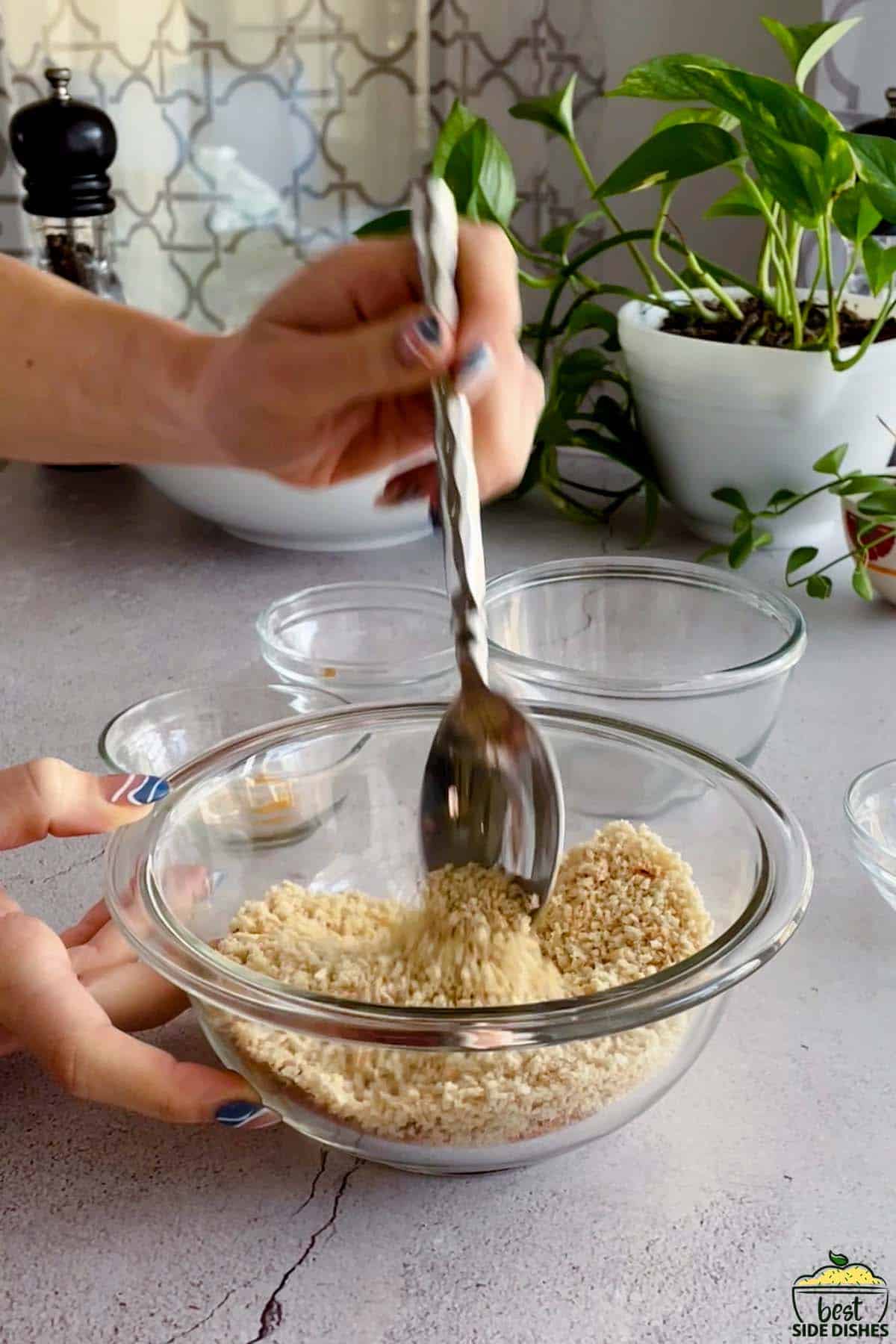 mixing breadcrumbs in a bowl