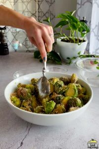 mixing breadcrumbs with brussels sprouts in a bowl