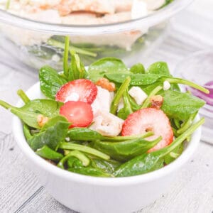spinach salad in a white bowl