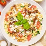 mediterranean couscous salad with feta cheese and basil on top