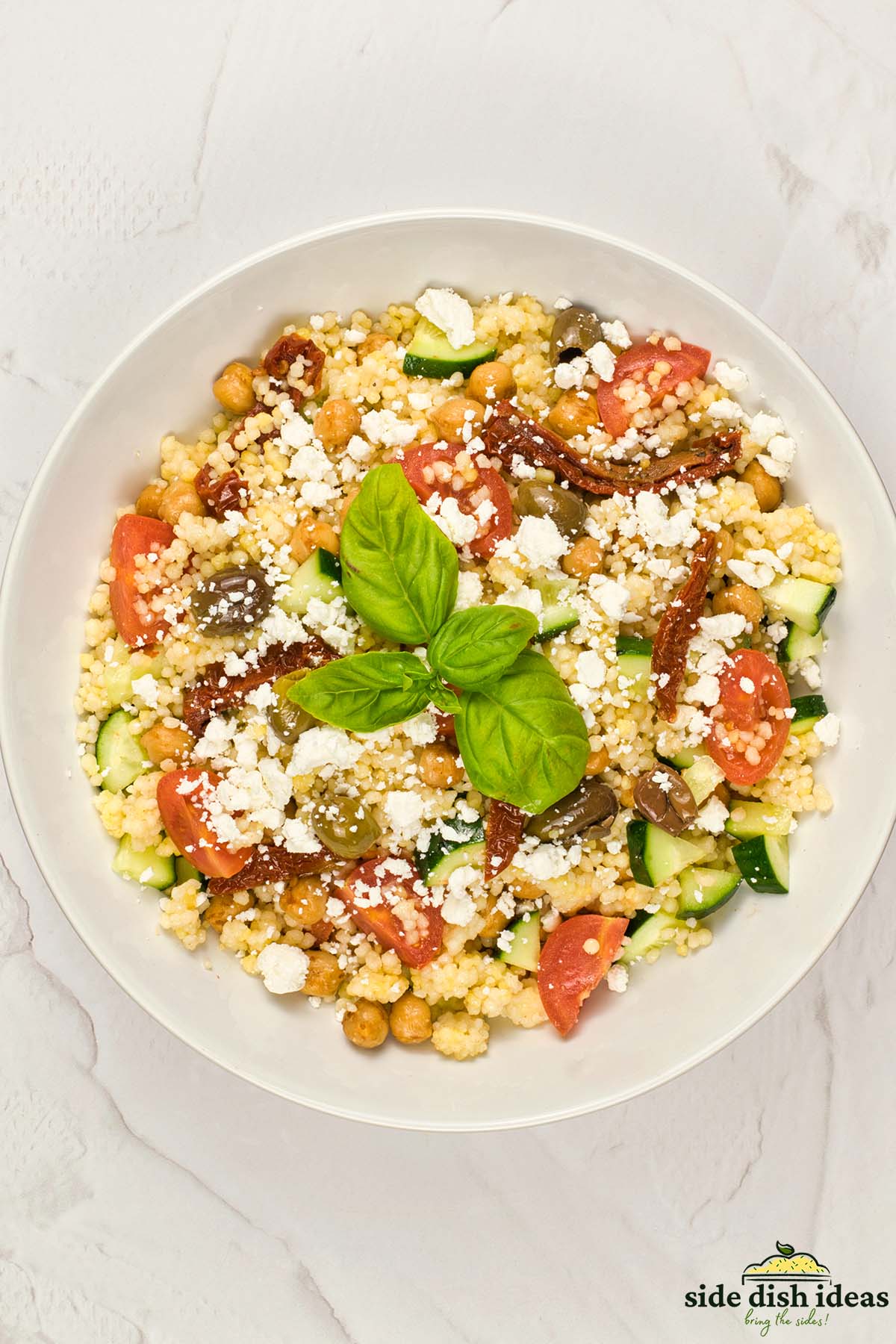 a bowl of mediterranean couscous salad after mixing