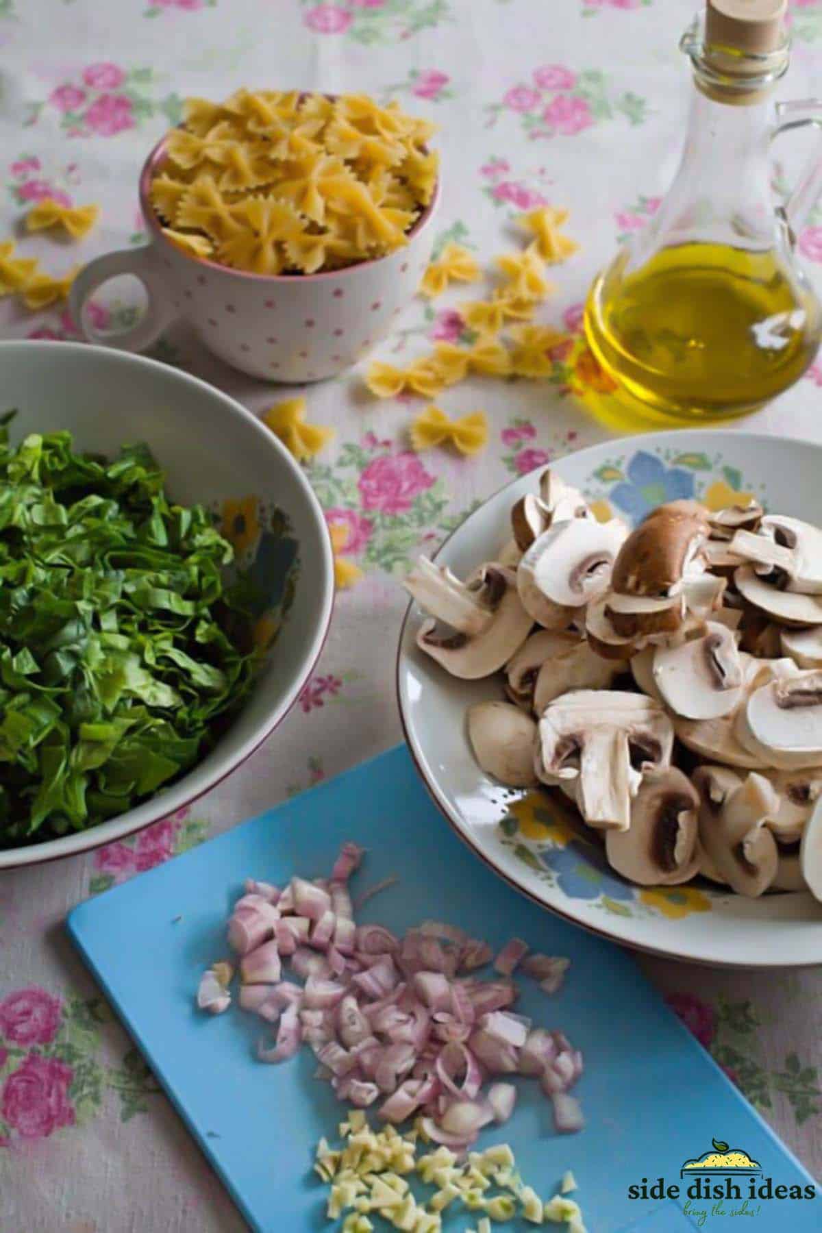 ingredients to make pasta with spinach and mushrooms in bowls