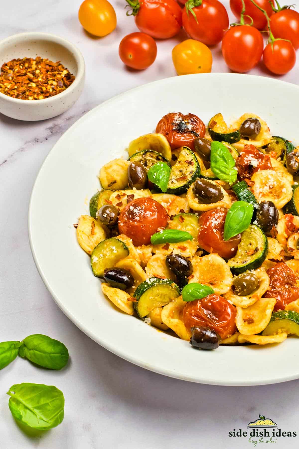 a bowl of summer pasta with extra basil, chili and tomatoes