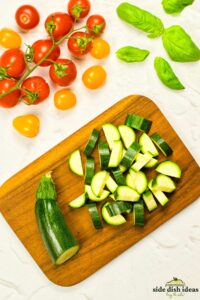 zucchini chopped into bite sized pieces on a cutting board