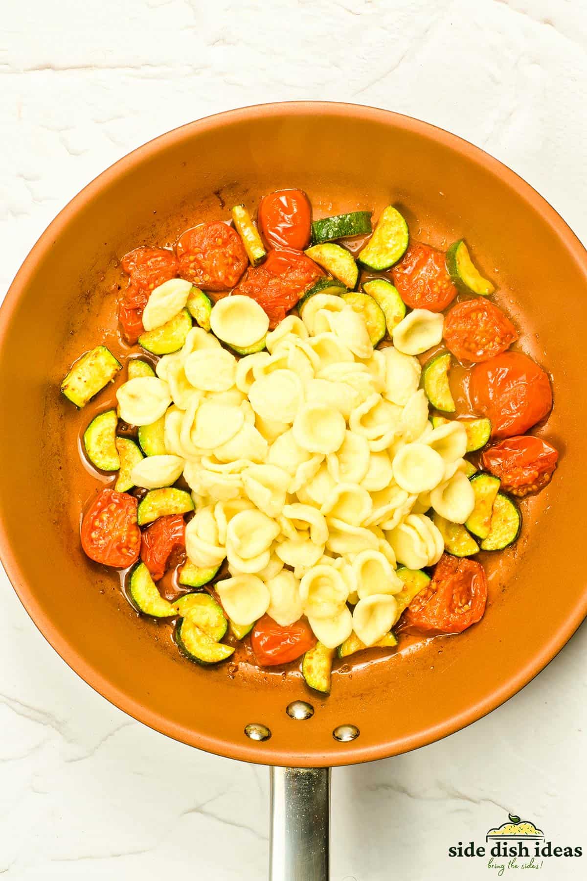 the pasta added to the pan of cooked vegetables