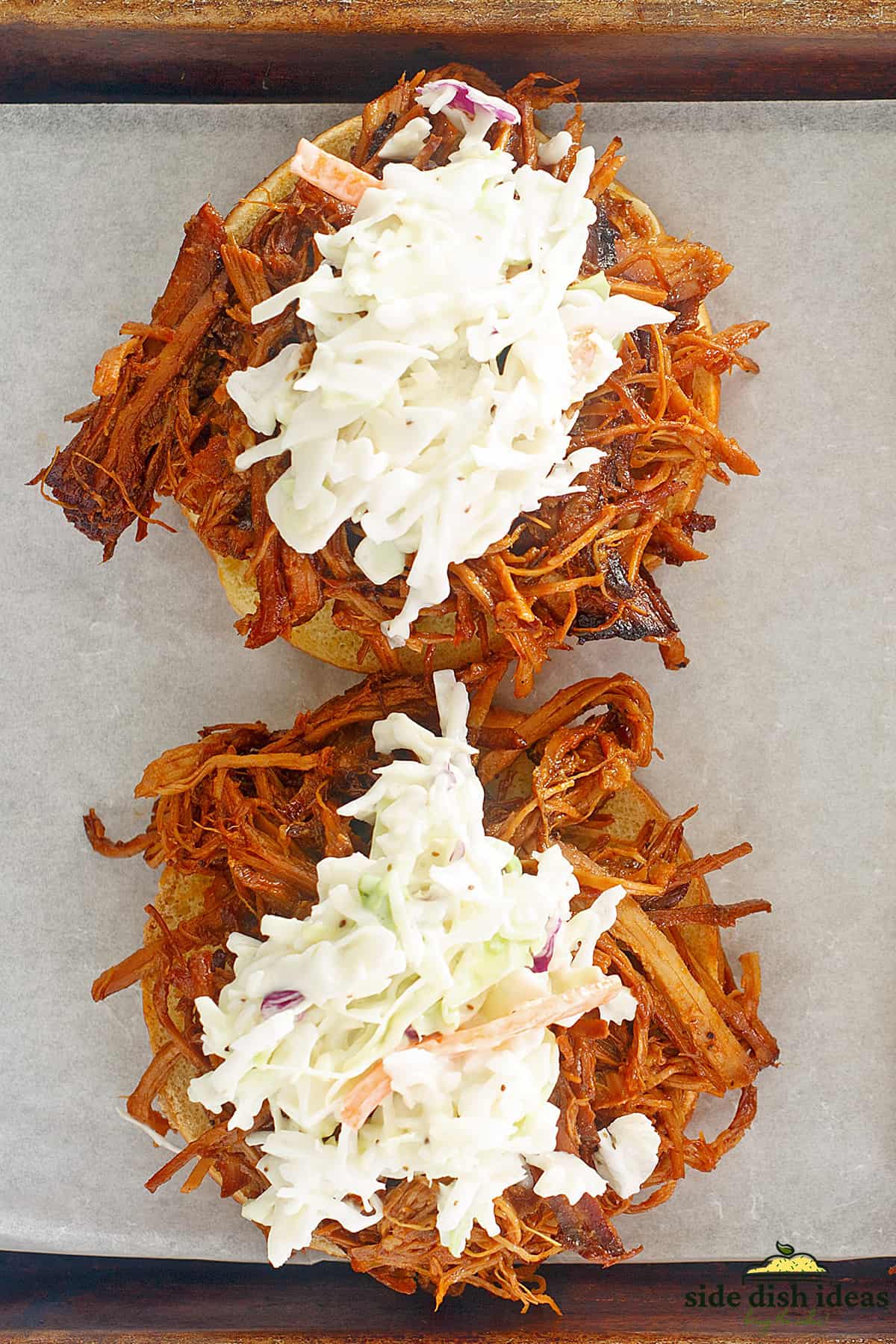 coleslaw on top of two pulled pork sandwiches