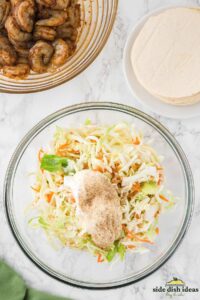 coleslaw dressing added to a bowl with slaw mix