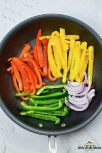 adding veggies for fajitas to a pan