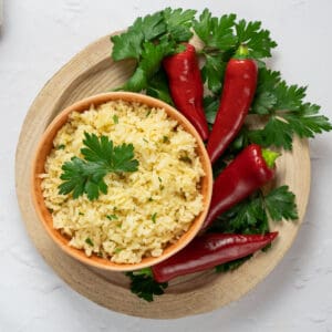 rice in a orange dish with cilantro and peppers on the side