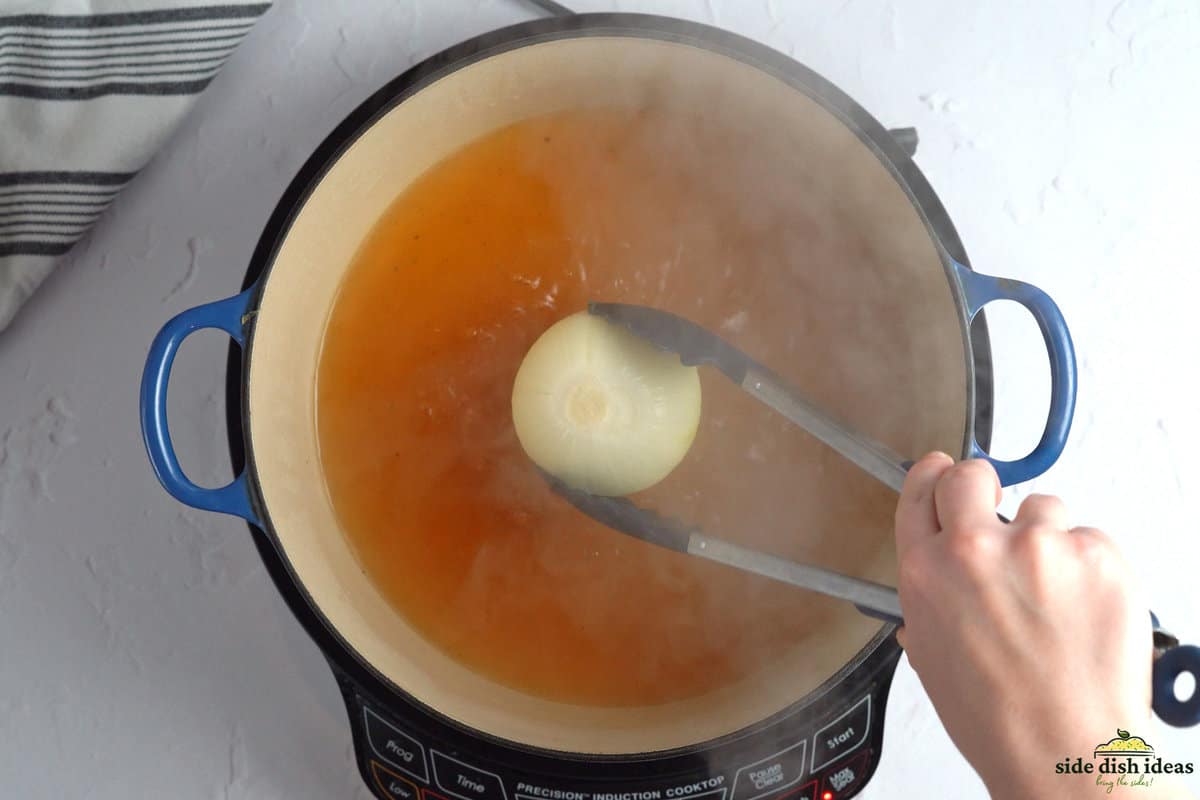 adding an onion to boiling water