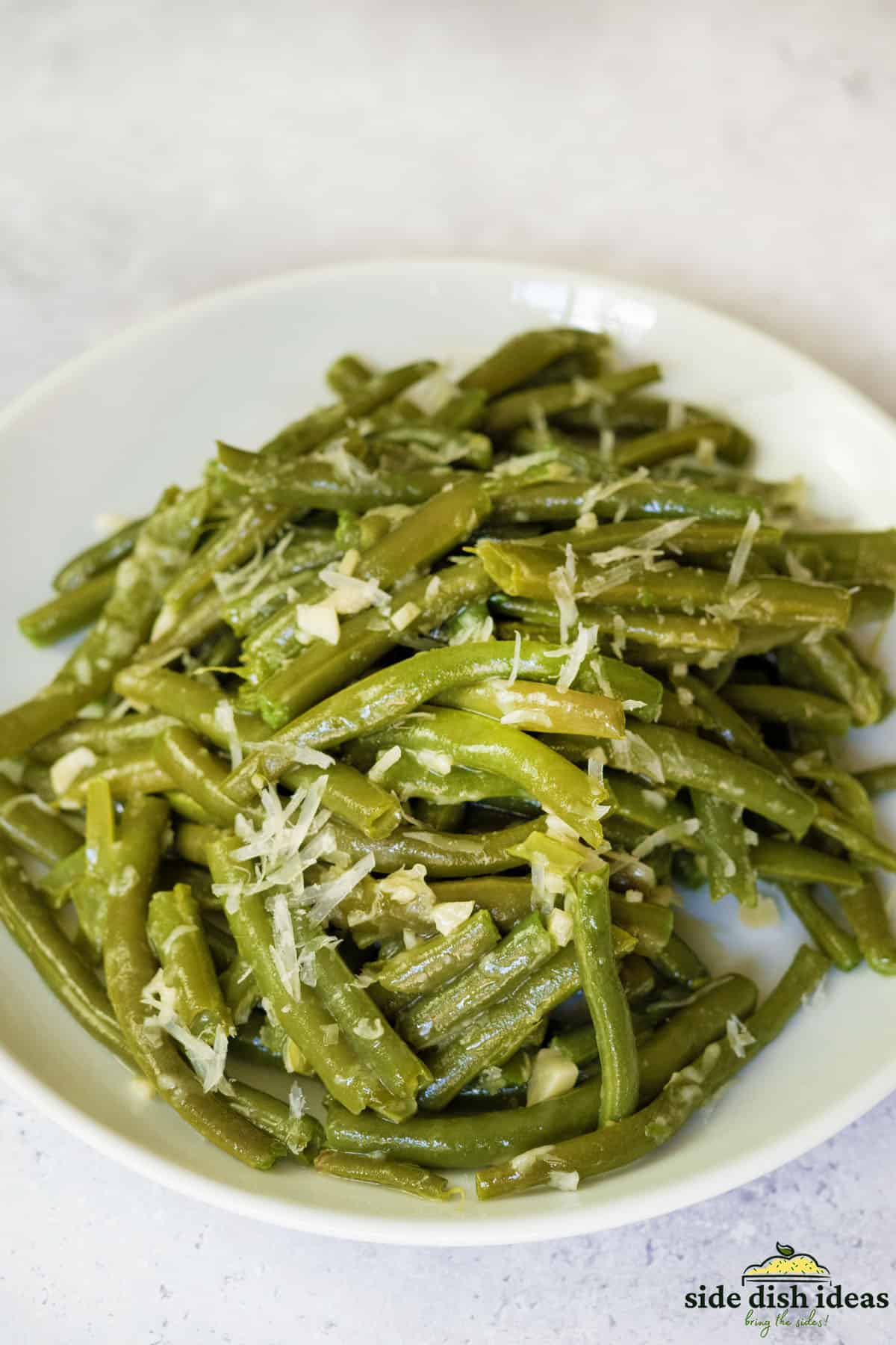 instant pot green beans and shredded cheese on a white plate