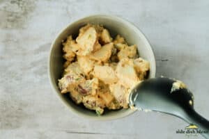 spooning mustard potato salad into bowls