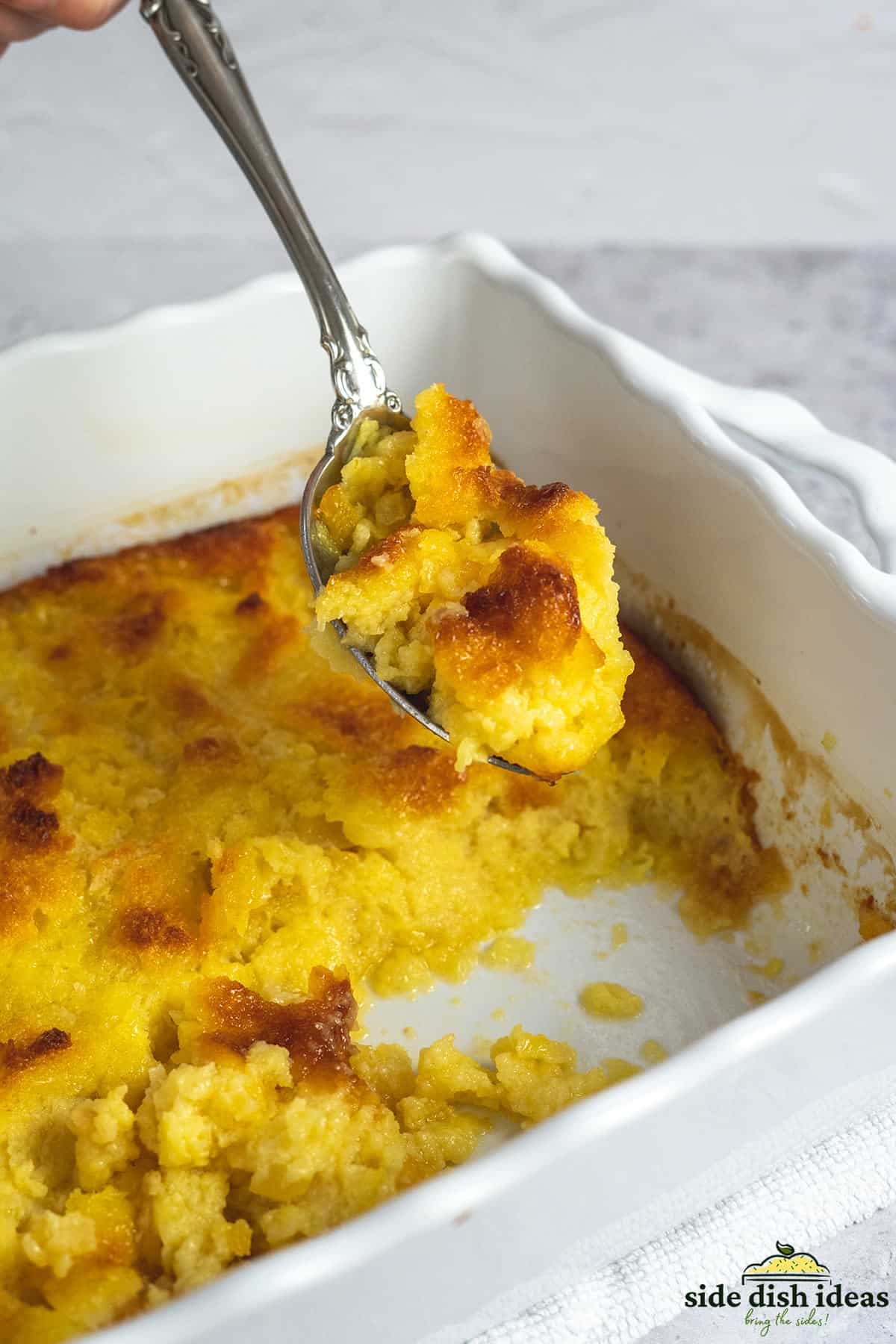 pineapple casserole with a spoon holding up a bite