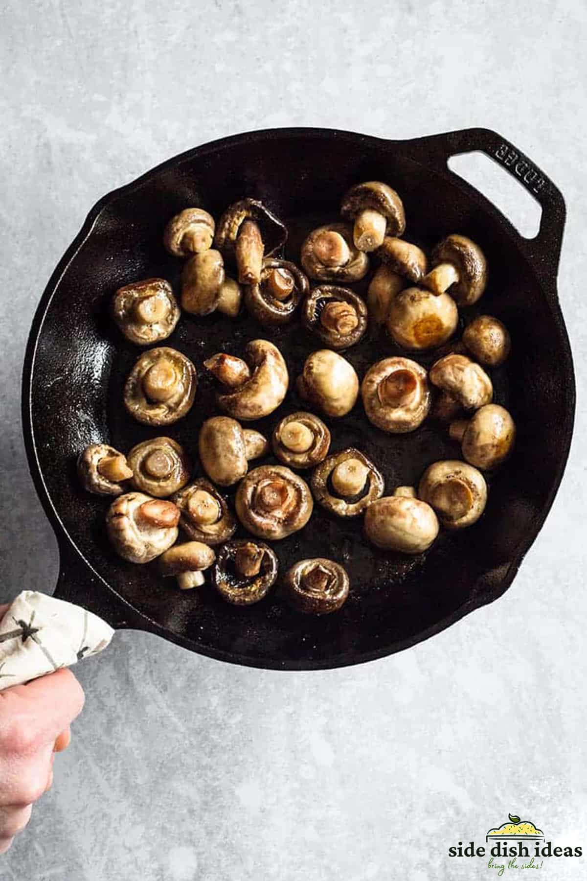 cooking white button mushrooms in a skillet
