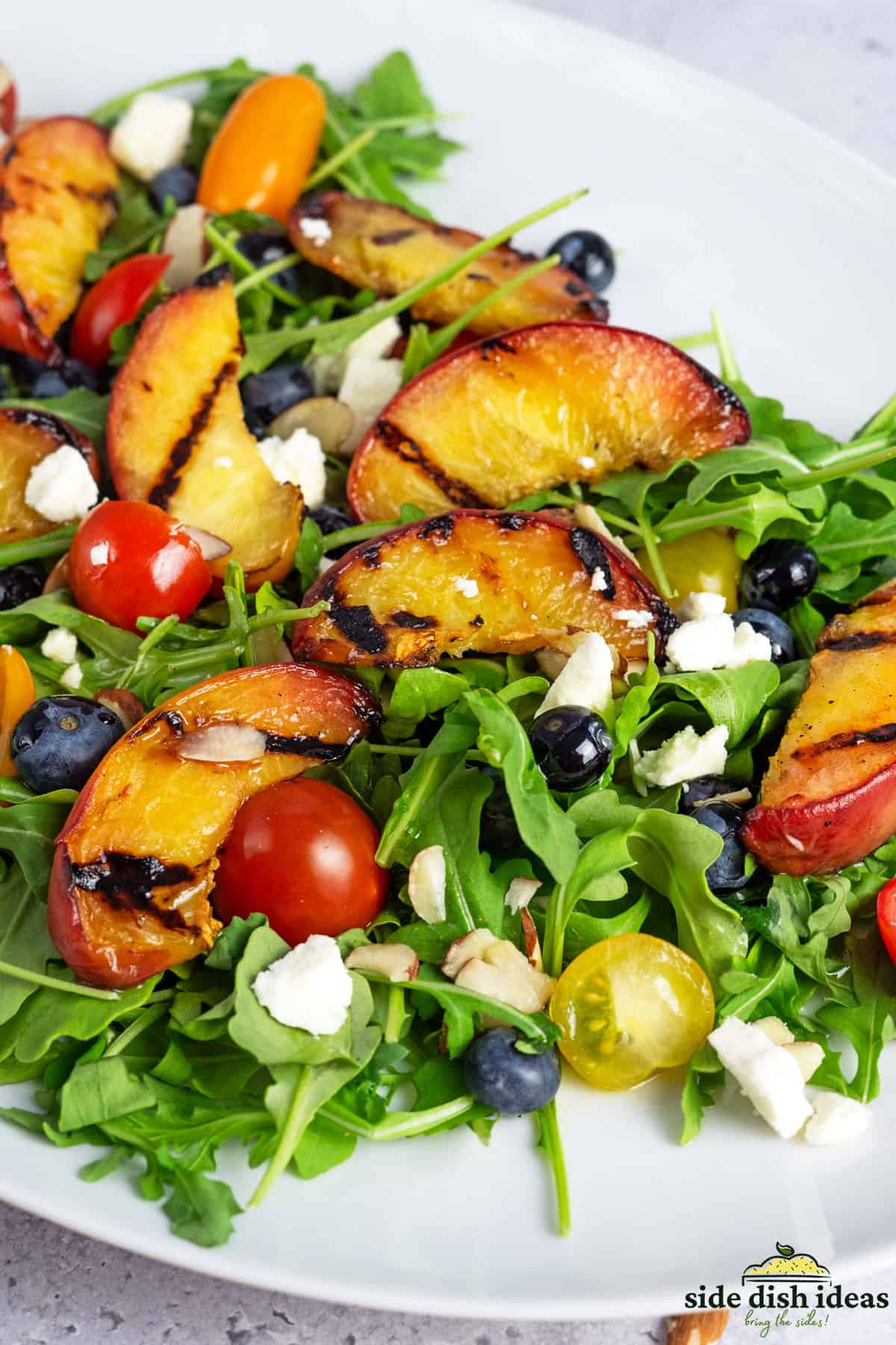 grilled peach salad on a white plate