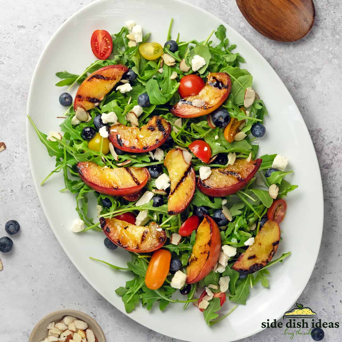 grilled peach salad on a white platter