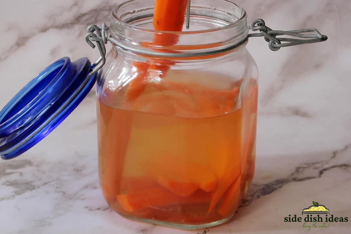 removing a pickled carrot from glass jar