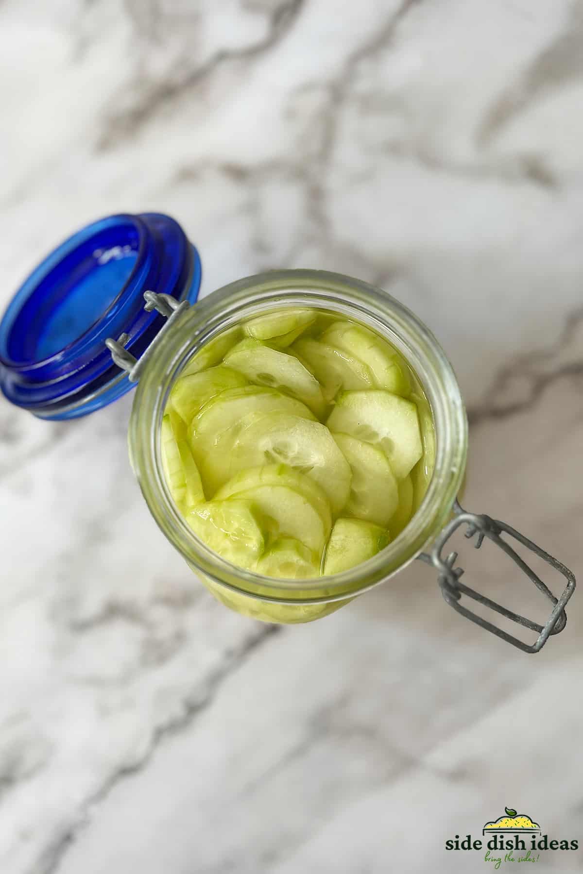 pickled cucumbers inside of a glass jar with an open lid