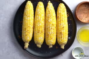 brushing corn with seasoning