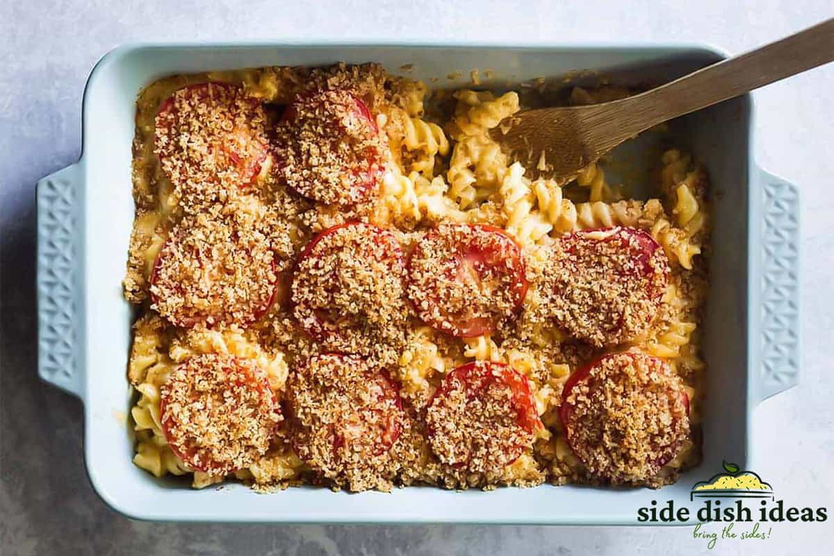 creamy baked mac and cheese with tomatoes and breadcrumbs in a baking dish