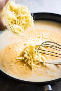 adding cheese to roux in skillet