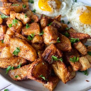seasoned potatoes on a plate with eggs