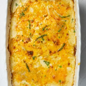 close up of scalloped potatoes in white baking dish